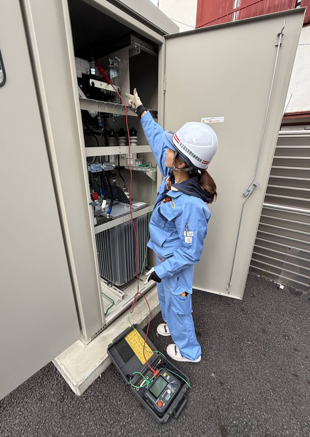 電気設備の現場で点検する技術者
